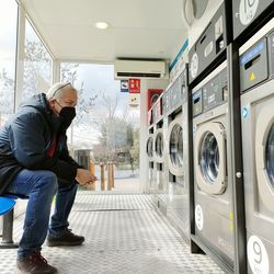 Man sitting in front of washing machines