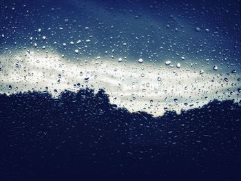 Full frame shot of wet window against sky