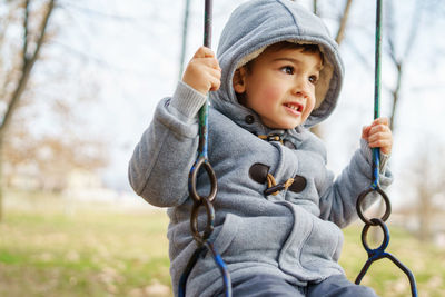 Cut boy sitting on swing