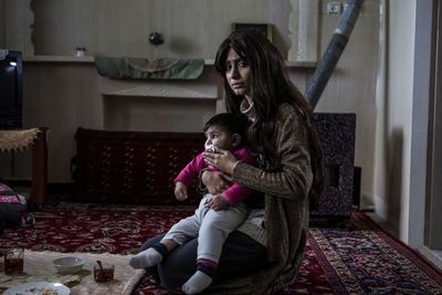 Mother and daughter sitting at home