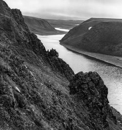 Scenic view of river by mountain against sky