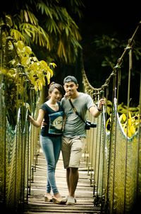 Portrait of couple standing on footbridge