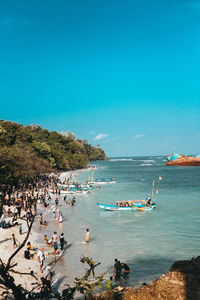 People enjoying at beach against sky