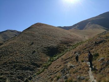 Rear view of man and woman walking on mountain