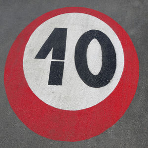 Large number 10 of a speed limit sign written on the asphalt of the road