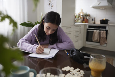 Girl doing homework at dining table