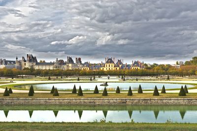 Scenic view of lake by buildings against sky