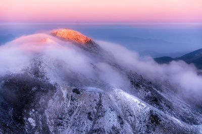 Scenic view of snowcapped mountains against sky during sunset