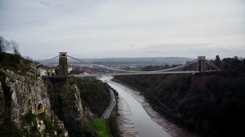 Bridge over river in city against sky