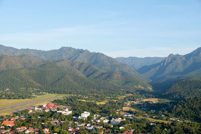 Asphalt runway of the small airport in the valley surrounded by high mountains.