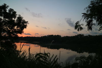 Scenic view of lake against sky at sunset