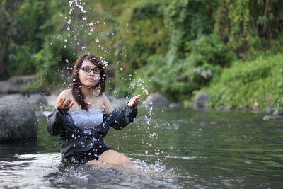 Young woman splashing water in lake