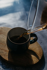 Close-up of coffee getting poured in cup on table