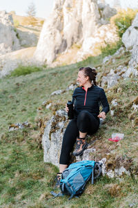 Woman sitting on a rock while having a break during hiking.