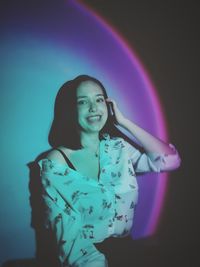 Young woman standing against black background