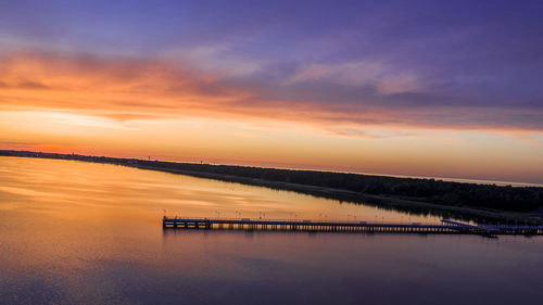 Scenic view of lake against orange sky