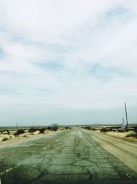 Road passing through landscape against sky