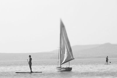 Rear view of woman walking on beach against clear sky