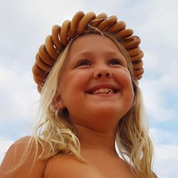 Low angle view of smiling girl against sky