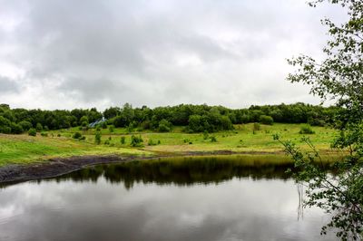 Scenic view of lake against cloudy sky