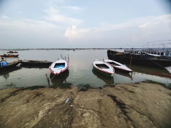 Boat moored on shore against sky