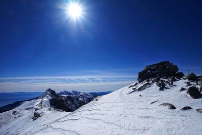 Scenic view of snowcapped mountains against blue sky