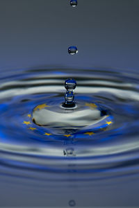 Close-up of drop falling on blue water