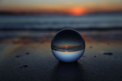 Close-up of crystal ball at the beach at sunset