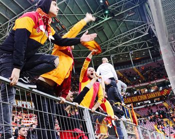 Low angle view of people on railing