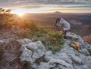 Photographer taking picture. woman artist photo enthusiast stay with camera above valley and works