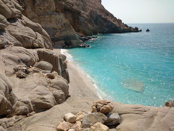 Rock formations by turquoise sea