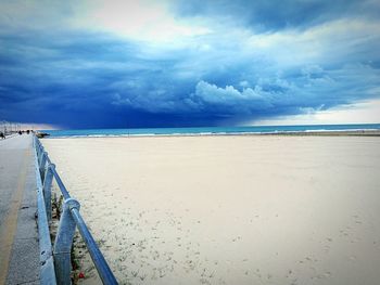 Scenic view of beach against cloudy sky