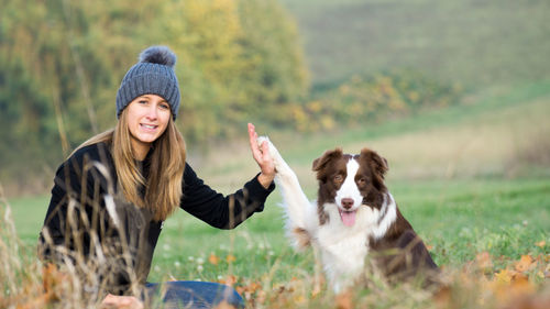 Portrait of woman with dog on grass