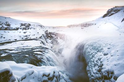 Scenic view of waterfall against sky during winter