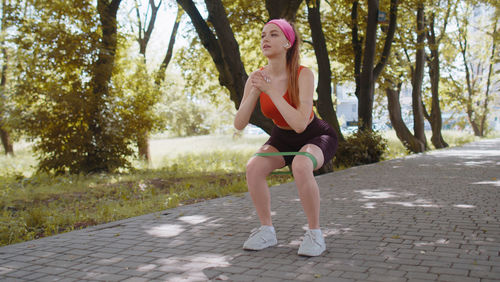 Full length of young woman exercising in park