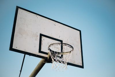 Low angle view of basketball hoop against blue sky