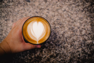 High angle view of hand holding coffee