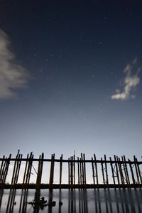 Low angle view of railing against sky at night