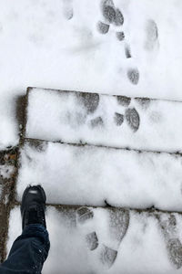Low section of person on snow covered shoes