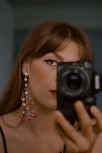 Close-up of young woman with camera