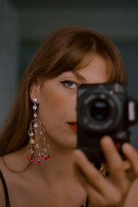 Close-up of young woman with camera