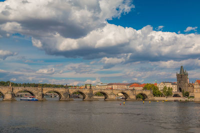 Arch bridge over river against buildings