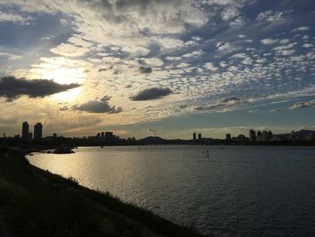 Silhouette of city against cloudy sky