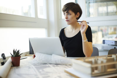 Architect sitting at desk looking through window