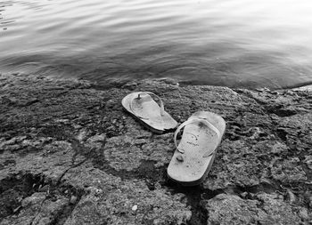 High angle view of shoes on rocks by sea