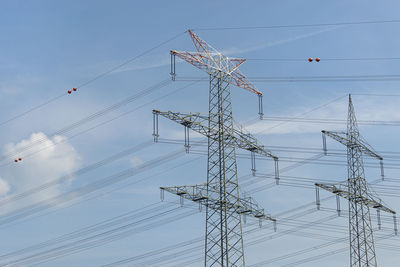 High voltage lines and power pylons against a gray sky background.