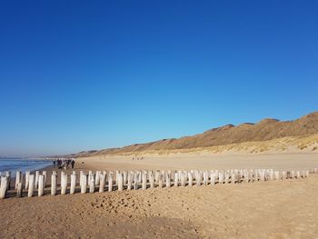 Scenic view of beach against clear blue sky