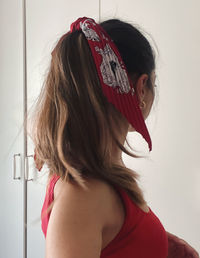 Close-up portrait of a young woman against wall