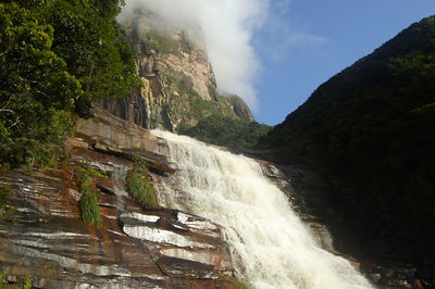 Scenic view of waterfall against sky