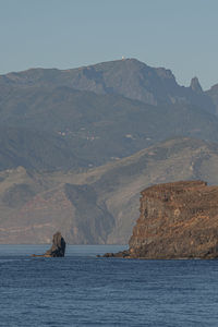 Scenic view of sea and mountains against sky